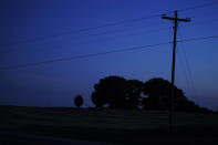 Lights illuminate inside a cemetery where David Guess, 51, of Athens, Ala., is buried on Thursday, June 23, 2022, in Athens, Ala. Guess, a 51-year-old small-town father of four struggled with addiction. Police say he was shot by an acquaintance and dumped in an Alabama forest near a place called Chicken Foot Mountain. (AP Photo/Brynn Anderson)