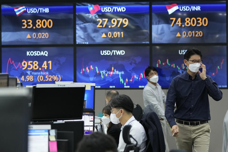 Currency traders pass by screens showing foreign exchange rates at the foreign exchange dealing room of the KEB Hana Bank headquarters in Seoul, South Korea, Friday, Oct. 8, 2021. Asian stocks followed Wall Street higher Friday after U.S. lawmakers temporarily averted a possible government debt default while investors waited for American jobs numbers. (AP Photo/Ahn Young-joon)