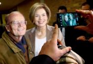 A man takes a picture of Julia Kloeckner, leader of the conservative Christian Democratic Union party CDU in the federal state of Rhineland-Palatinate, and an unidentified man during regional elections at a polling station in Bad Kreuznach, in the German federal state of Rhineland-Palatinate, March 13, 2016. REUTERS/Kai Pfaffenbach