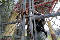 FILE - In this March 13, 2020 file photo, School Resource Officer Donald Lee locks the gates of the Dr. Martin Luther King, Jr. Elementary School for Science and Technology, after all the students left, in New Orleans. Where political divides marred early recovery efforts after Hurricane Katrina in 2005, Louisiana is showing rare political unity in the fight against the new coronavirus. (AP Photo/Gerald Herbert, File)