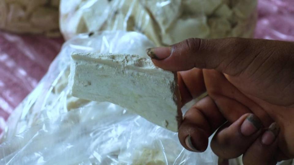 Un campesino muestra un pedazo de pasta base de coca, usada para la producción de cocaína, en el sector del río Micay, departamento del Cauca, Colombia, en marzo de 2024.