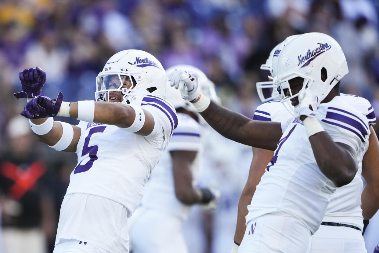 Northwestern linebacker Kenny Soares Jr. (5) and defensive lineman Anto Saka, right, celebrate a sack of Washington quarterback Will Rogers during the first half of an NCAA college football game Saturday, Sept. 21, 2024, in Seattle. (AP Photo/Lindsey Wasson)