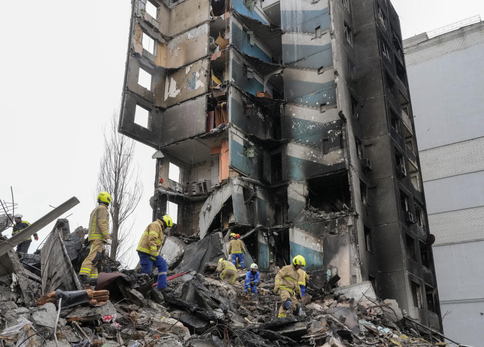Emergency workers shift the rubble from a multi-storey building destroyed in a Russian attack, at the beginning of the Russia-Ukraine war in Borodyanka, close to Kyiv, Ukraine, Saturday, April 9, 2022.  (AP Photo/Efrem Lukatsky)