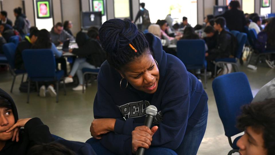 Akua Willis, a substitute teacher, talks to a table of students as she  conducts a lesson the multipurpose room at Vista Middle School.