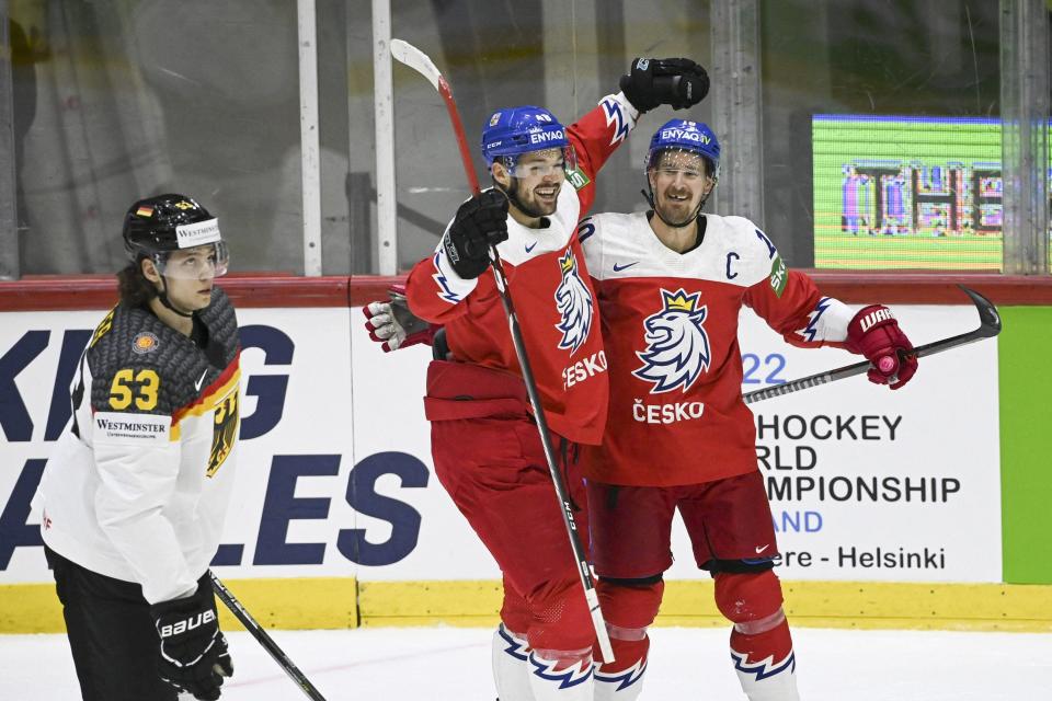 Czechia forwards Tomas Hertl and Roman Cervenka, right, celebrate a goal next to German defender Moritz Seider (L) during the IIHF Ice Hockey World Championships quarterfinal match in Helsinki, Finland, on May 26, 2022.