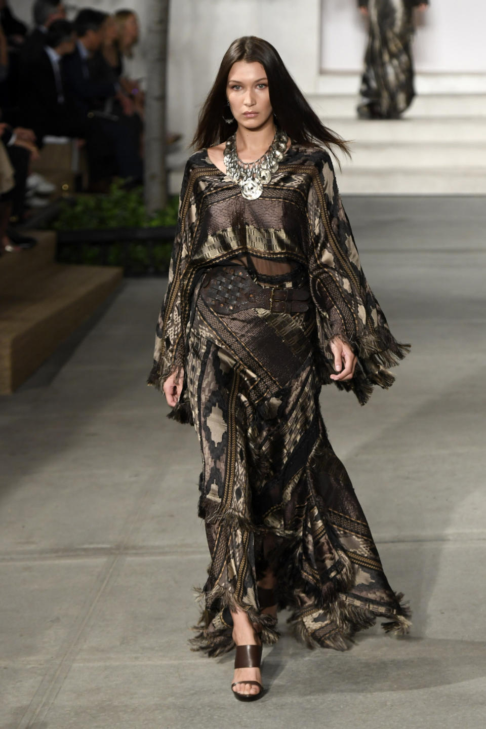 <p>Also at the Ralph Lauren Show, Bella Hadid sashayed down the catwalk in a fringed boho chic dress. <i> [Photo: Getty]</i></p>