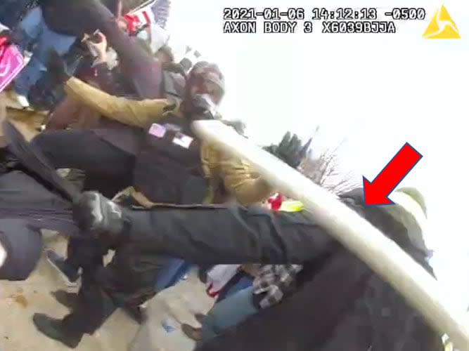 Homol's flagpole indicated with a red arrow as it strikes the officer wearing the camera.