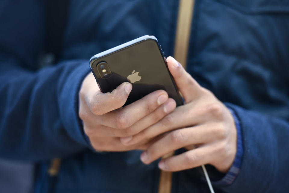 A customer views an Apple Inc. iPhone X smartphone during the sales launch at a store in San Francisco, California, U.S., on Friday, Nov. 3, 2017. The $1,000 price tag on Apple Inc.'s new iPhone X didn't deter throngs of enthusiasts around the world who waited -- sometimes overnight -- in long lines with no guarantee they would walk out of the store with one of the coveted devices. Photographer: Michael Short/Bloomberg via Getty Images