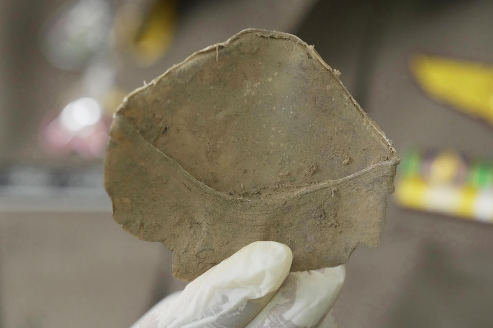 A Thai official displays seized pangolin scales during a news conference at the Natural Resources and Environmental Crime Division in Bangkok, Thailand, Thursday, Aug. 17, 2023. Thai authorities say they have seized more than a ton of pangolin scales worth over 50 million baht ($1.4 million) believed to be on the way out of the country through a land border. (AP Photo/Sakchai Lalit)