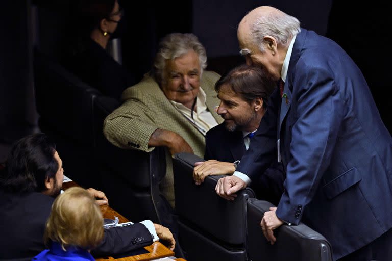 El expresidente de Uruguay (2010-2015) José Mujica; el presidente de Uruguay, Luis Lacalle Pou, y el expresidente de Uruguay (1985-1990,1995-2000) Julio María Sanguinetti conversan con otros invitados mientras esperan la llegada del presidente Luiz Inacio Lula da Silva en el Congreso para su ceremonia de toma de posesión, en Brasilia, el 1 de enero de 2023. (MAURO PIMENTEL / AFP)