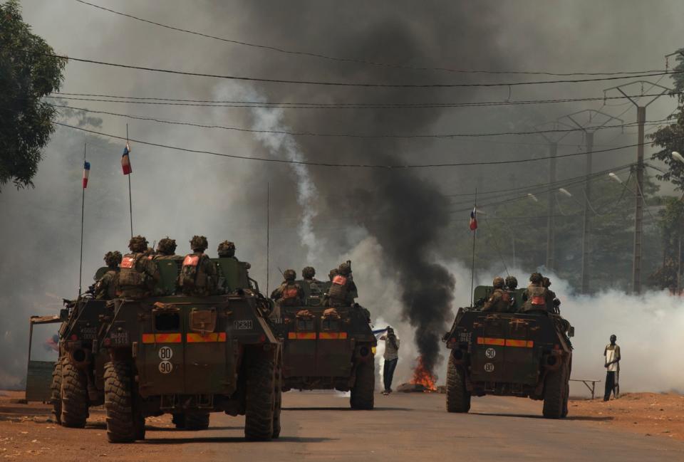 FILE - In this Sunday, Dec. 22, 2013 file photo, French soldiers fire tear gas as they attempt to contain a demonstration calling for the departure of French forces, in Bangui, Central African Republic. Several dozen Muslim supporters of Seleka burned tires and blocked a road Sunday, carrying signs that read 'No to France.' Sub-Saharan Africa has seen a very violent start to 2014 with raging conflicts in South Sudan and Central African Republic - the death tolls are huge and the individual incidents gruesome, with one estimate saying nearly 10,000 have been killed in South Sudan in a month of warfare. (AP Photo/Rebecca Blackwell, File)