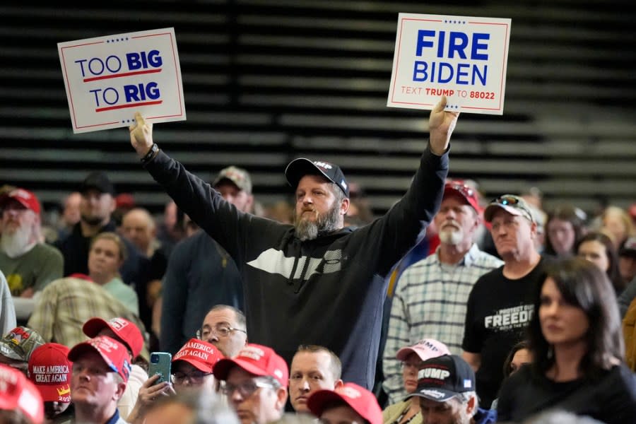 A supporter holds signs as Republican presidential candidate former President Donald Trump speaks at a campaign rally Saturday, March 2, 2024, in Greensboro, N.C. (AP Photo/Chris Carlson)