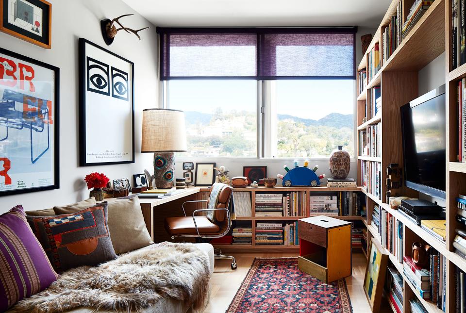 Posters from a trip to Copenhagen and the Bauhaus hang in the den. Shade by the Shade Store; Eames leather chair.