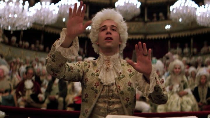 Tom Hulce as Wolfgang Amadeus Mozart conducting in front of a large crowd in Amadeus.