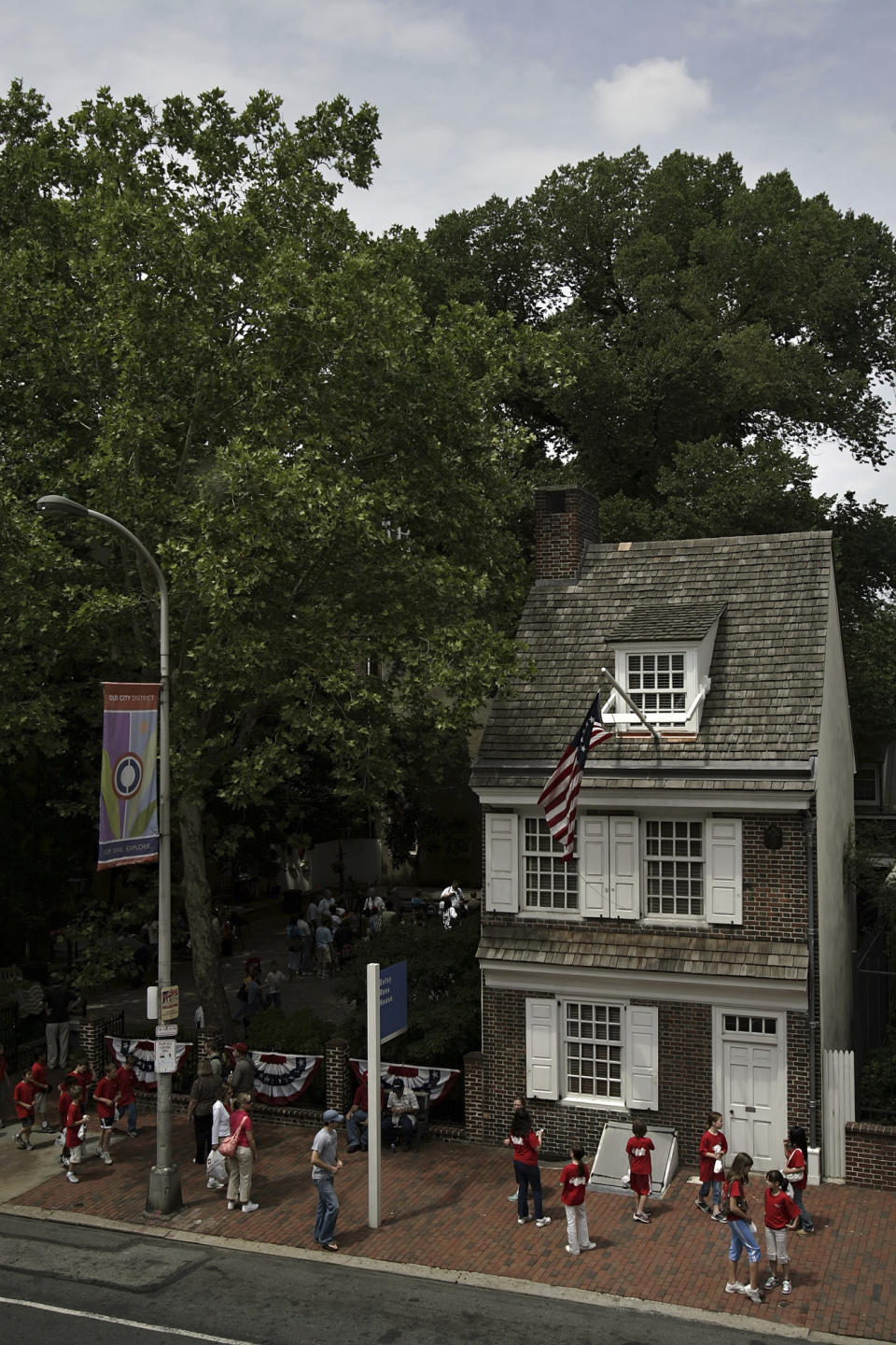 FILE - The Betsy Ross house is seen in Philadelphia, June 6, 2006. In the bedroom setting of the Betsy Ross House, a reconstruction of where the upholsterer would have worked on her most famous commission, a long flag with a circle of 13 stars hangs over a Chippendale side chair and extends across the floor. (AP Photo/Matt Rourke, File)