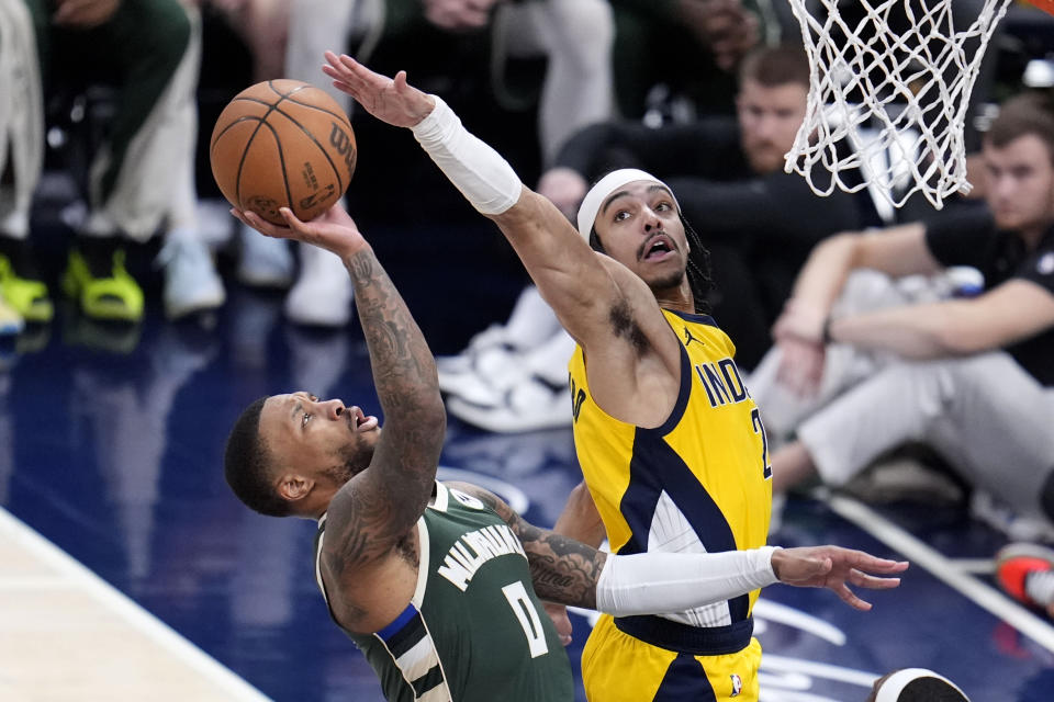 Milwaukee Bucks guard Damian Lillard (0) shoots over Indiana Pacers guard Andrew Nembhard (2) during the second half in Game 6 in an NBA basketball first-round playoff series, Thursday, May 2, 2024, in Indianapolis. (AP Photo/Michael Conroy)