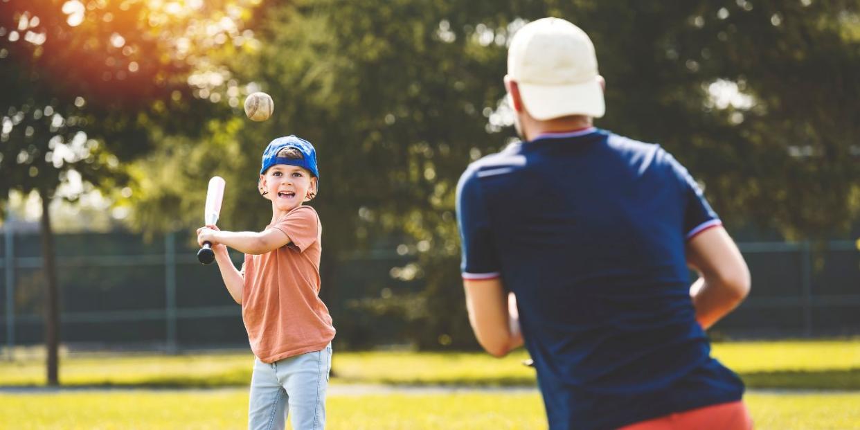 little boy and dad playing baseball- we're a baseball family