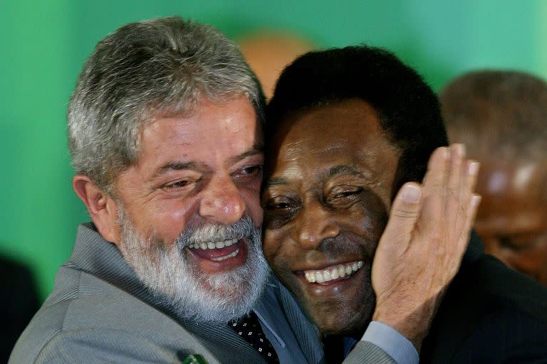 En esta foto del 26 de junio de 2008, el presidente brasileño, Luiz Inacio Lula da Silva, abraza a la leyenda del fútbol brasileño Edson Arantes do Nacimento, conocido como Pelé, mientras condecora a los ganadores de la Copa del Mundo de 1958