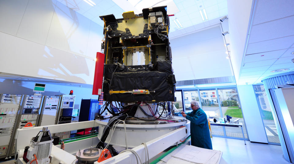 A scientist of European space agency ESA stands at an airworthy copy of space probe 'Rosetta' in the ESA control center in Darmstadt, Germany, Monday, Jan. 20, 2014. Scientists at the European Space Agency are expecting their comet-chasing probe Rosetta to wake from almost three years of hibernation at 11 a.m. Monday Jan. 20, 2014 (1000 GMT; 5 a.m. EST) and phone home to say all is well. The scientists are facing an agonizing wait of several hours until the first signal reaches Earth. (AP Photo/dpa, Daniel Reinhardt)