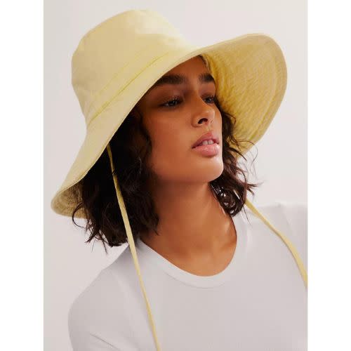model wearing yellow drawstring hat