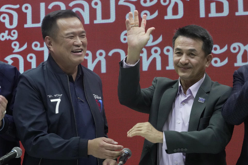 Leader of Bhumjaithai Party Anutin Charnvirakul, left and Leader of Pheu Thai party Chonlanan Srikaew wave after press conference for coalition party at Thai Party headquarters in Bangkok, Thailand, Monday, Aug. 7, 2023. The populist Pheu Thai Party on Monday announced it will assemble a coalition with the Bhumjaithai Party from the outgoing administration to solve the months long political deadlock. (AP Photo/Sakchai Lalit)