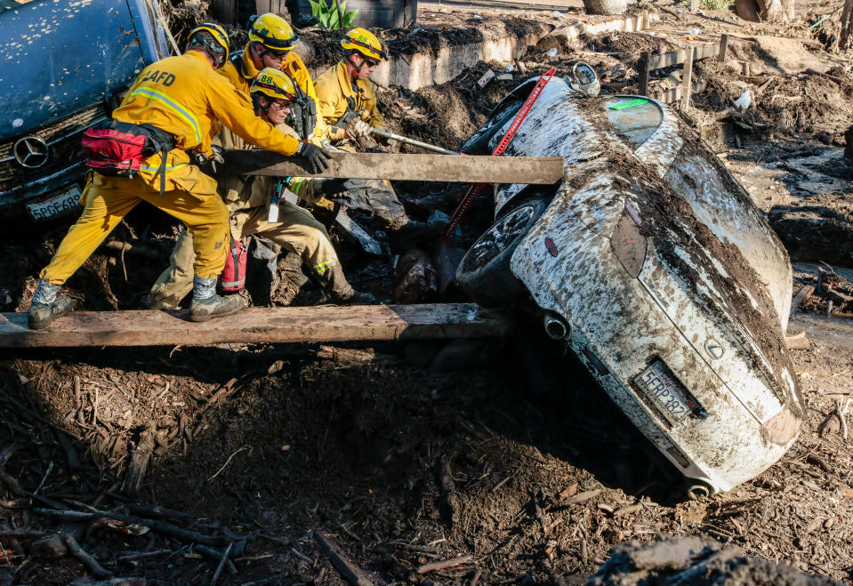 <p>Rescue workers search in an around cars for missing persons after a mudslide in Montecito, Calif., Jan. 12, 2018. (Photo: Kyle Grillot/Reuters) </p>