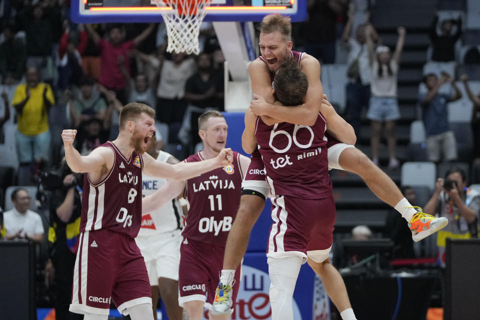 Latvia players celebrate after defeating France in their Basketball World Cup group H match at the Indonesia Arena stadium in Jakarta, Indonesia, Sunday, Aug. 27, 2023. (AP Photo/Achmad Ibrahim)