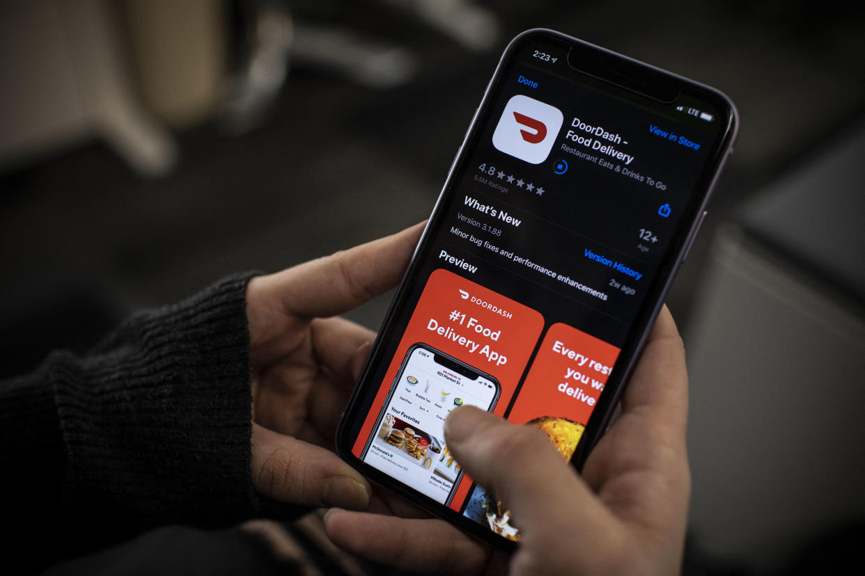 AFP journalist checking DoorDash food delivery application on her smartphone, with DoorDash preparing to go public