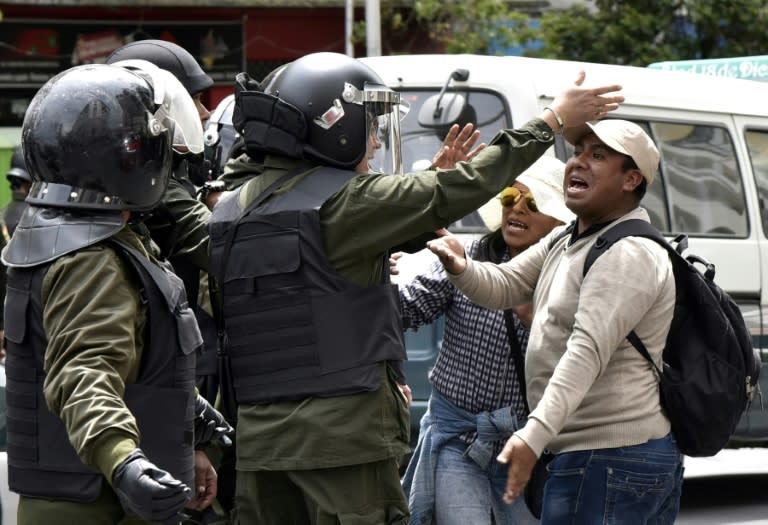 People argue with policemen during a march against the nomination of Bolivian President Evo Morales as a candidate for reelection for the October 2019 elections, during a national strike, in La Paz, on December 6, 2018