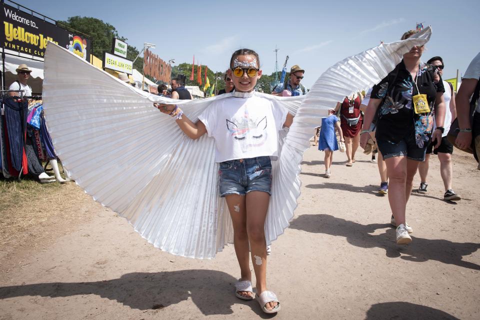 Young Festival goer wearing fancy dress wings walks on site on day 3 of Glastonbury 2019, Worthy Farm, Pilton, Somerset. Picture date: Friday 28th June 2019.  Photo credit should read:  David Jensen/EmpicsEntertainment