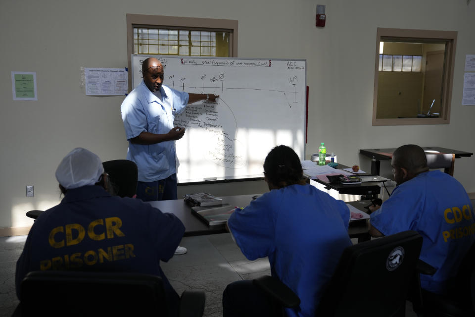 Mentor Harry Goodall leads a history discussion in the Peer Literacy Mentor Program to incarcerated men during a media tour at San Quentin State Prison in San Quentin, Calif., on July 26, 2023. California Gov. Gavin Newsom has ambitious and expensive plans for a dilapidated factory at San Quentin State Prison where inmates of one of the nation's most notorious lockups once built furniture. He wants to spend $360 million demolishing the building and replacing it with one more reminiscent of a college campus, with a student union, classrooms and possibly a coffee shop. (AP Photo/Eric Risberg)