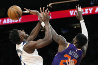 Phoenix Suns center Deandre Ayton, right, blocks a shot against Minnesota Timberwolves guard Anthony Edwards, left, during the first half of an NBA basketball game Wednesday, March 29, 2023, in Phoenix. (AP Photo/Ross D. Franklin)