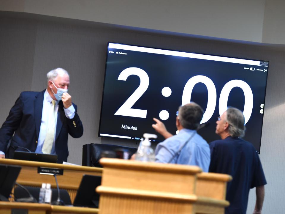 Augusta County School Board member Nick Collins, left, is confronted by two men during a September 2021 school board meeting. One of the men was speaking against mandatory masks in schools and demanded to see the faces of the school board members.