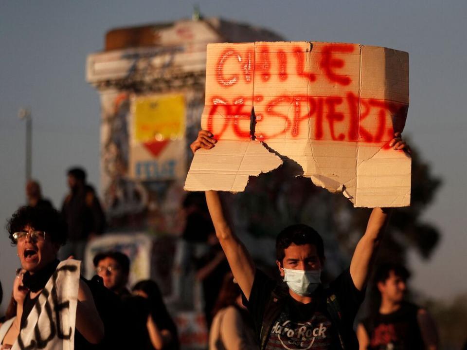 A protester who supported the new constitution draft holds a placard reading "Wake Up Chile" during a demonstration in demand of a new constitutional process, a day after voters rejected the draft in a referendum.