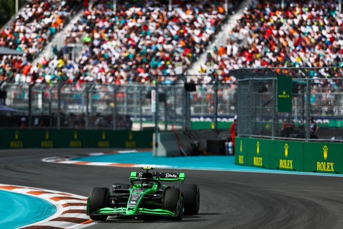 Formula 1 car races on track with spectator stands in the background