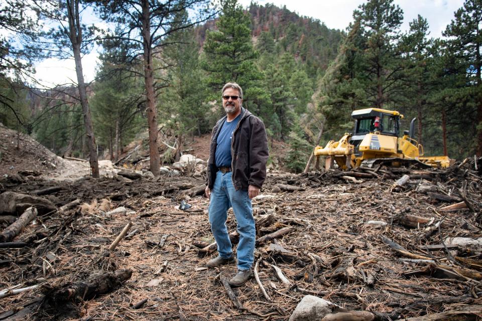 Dan Bond stands in a debris field that was left from the Black Hollow Creek flash flood, near his home in Rustic, Colo.