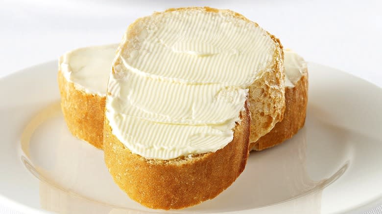 Buttered bread slices on a white plate 