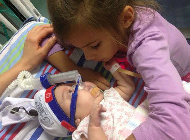 Hayley, Ms Kuiper's daughter from a previous relationship, cuddles her baby sister in the hospital. Picture: Supplied