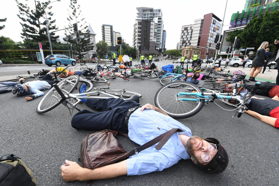 Cyclists block traffic during a ‘die-in’ protest, obstructing peak-hour traffic in Brisbane earlier this month. Source: AAP Image/Dave Hunt