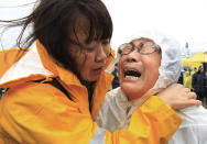 Relatives of a passenger aboard a sunken ferry weep as they wait for the news on the rescue operation, at a port in Jindo, South Korea, Thursday, April 17, 2014. Strong currents, rain and bad visibility hampered an increasingly anxious search Thursday for more than 280 passengers still missing a day after their ferry flipped onto its side and sank in cold waters off the southern coast of South Korea. (AP Photo/Ahn Young-joon)