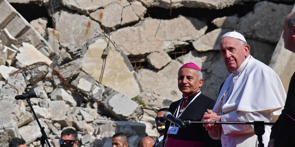 Pope Francis (R), accompanied by the Chaldean Catholic Archbishop of Mosul Najib Michaeel Moussa (2nd-R), looks on at a square near the ruins of the Syriac Catholic Church of the Immaculate Conception (al-Tahira-l-Kubra), in the old city of Iraq's northern Mosul on March 7, 2021. - Pope Francis, on his historic Iraq tour, visits today Christian communities that endured the brutality of the Islamic State group until the jihadists' "caliphate" was defeated three years ago (Photo by Vincenzo PINTO / AFP) (Photo by VINCENZO PINTO/AFP via Getty Images)