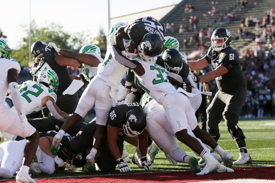 Washington State running back Nakia Watson (25) dives for a touchdown as Oregon linebackers Noah Sewell (1) and Jeffrey Bassa (33) try to stop him during the second half of an NCAA college football game, Saturday, Sept. 24, 2022, in Pullman, Wash.
(Credit: Young Kwak/AP)