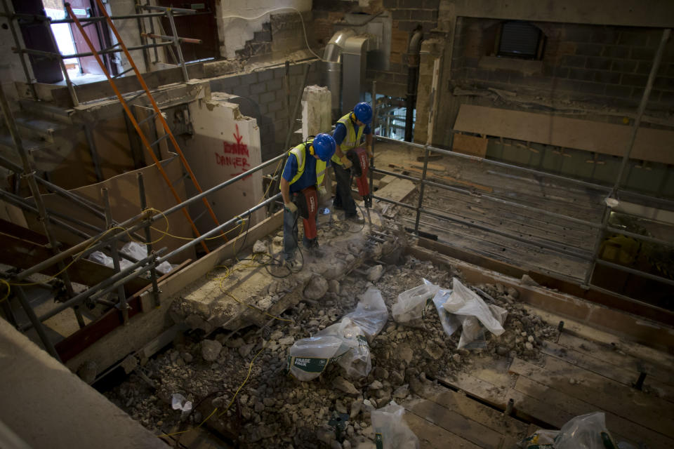 Builders pose for photographers as they carry out work on a new indoor venue at Shakespeare's Globe during an event for the media in London, Tuesday, Nov. 27, 2012. The new venue is named the Sam Wanamaker Theatre after the late American actor-director who spent decades realizing his dream of rebuilding Shakespeare's playhouse. It is due to open in January 2014, and will allow the Globe to hold performances year-round. (AP Photo/Matt Dunham)