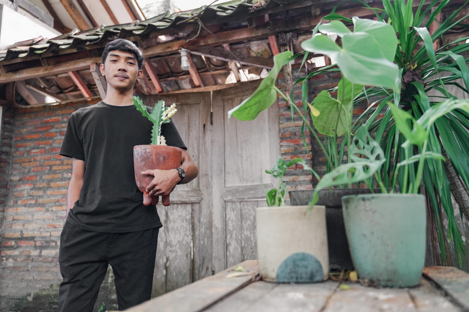 man holding a potted cactus