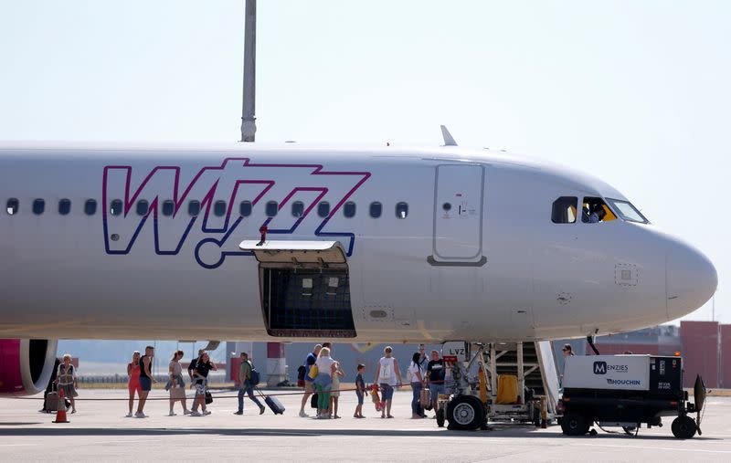 People stand next to a Wizz Air aircraft at Ferenc Liszt International Airport in Budapest