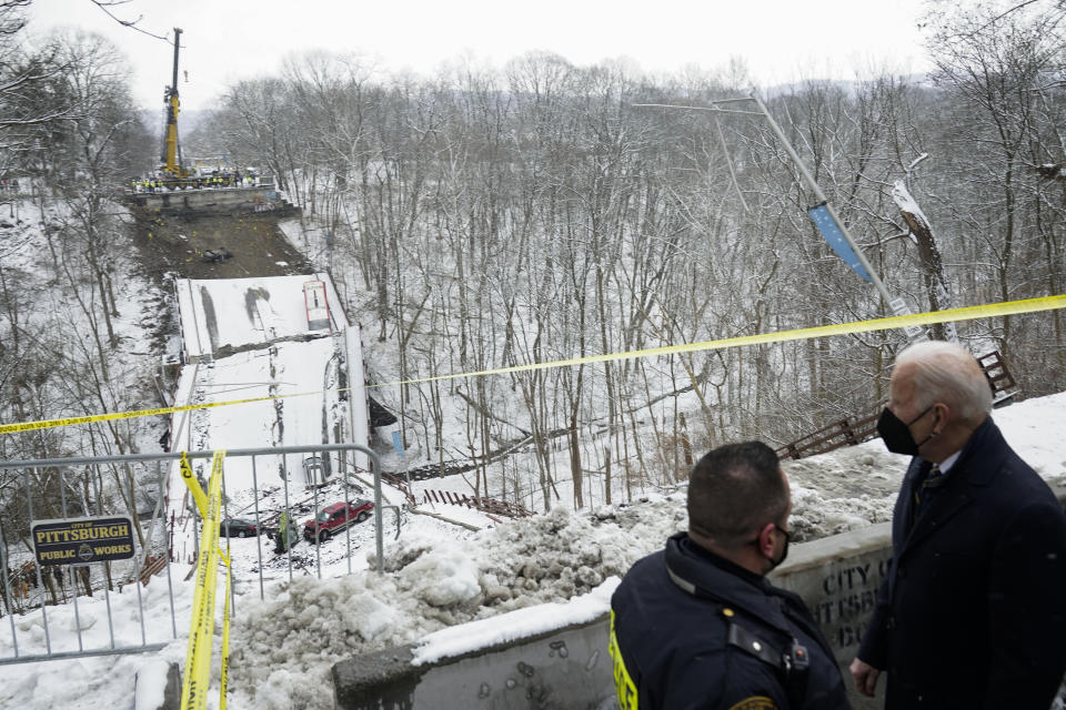 Vehicles that were on a bridge when it collapsed are visible as President Joe Biden visits the site where the Fern Hollow Bridge collapsed Friday, Jan. 28, 2022, in Pittsburgh's East End. (AP Photo/Andrew Harnik)