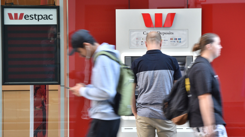 Customers standing in front of Westpac branch and ATM.