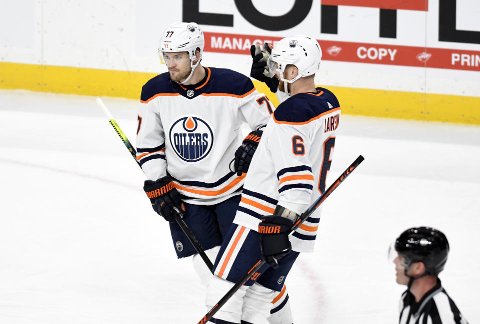 Edmonton Oilers' Oscar Klefbom, left, of Sweden, is congratulated by teammate Adam Larsson,right, of Sweden, after scoring a goal against the Minnesota Wild in the first period of an NHL hockey game, Thursday, Dec.12, 2019, in St. Paul, Minn. (AP Photo/Tom Olmscheid)