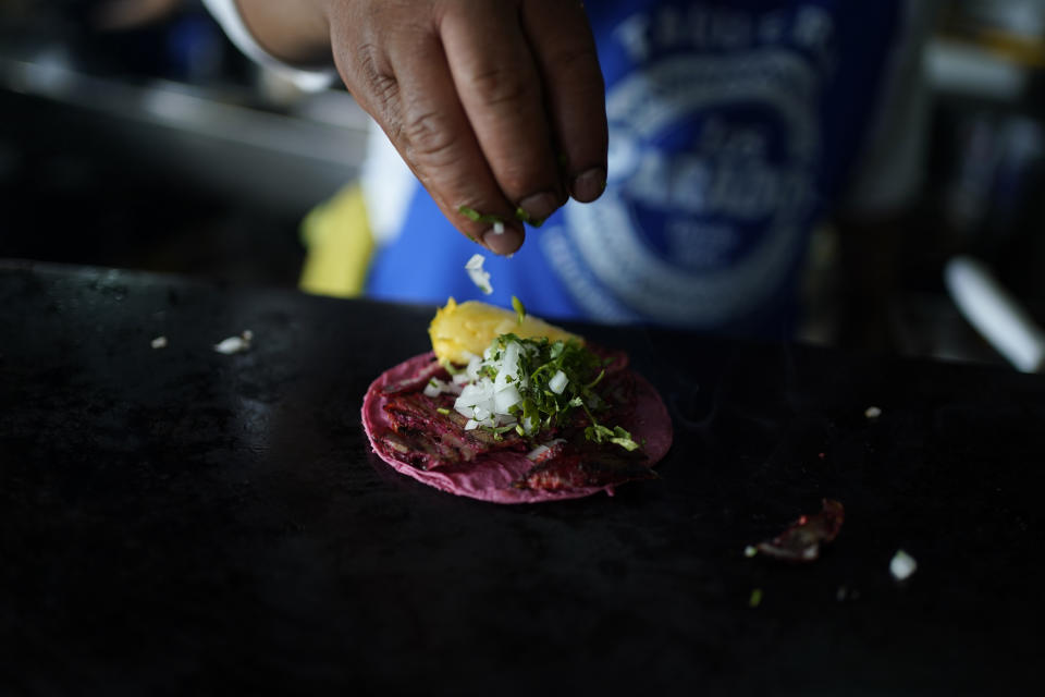 A cook prepares a taco with a Barbie themed pink tortilla at a restaurant in Mexico City, Thursday, July 20, 2023. The restaurant is offering tacos to its customers, made with these Barbie-themed tortillas where the corn dough is colored pink with beet juice. (AP Photo/Eduardo Verdugo)