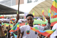 A man gestures as youth joining the Defense Forces gather, at Meskel Square, in Addis Ababa, Ethiopia, Tuesday, July 27 2021. A repatriation program is underway for young people from Ethiopia who have decided to join the Defense Forces. (AP Photo)